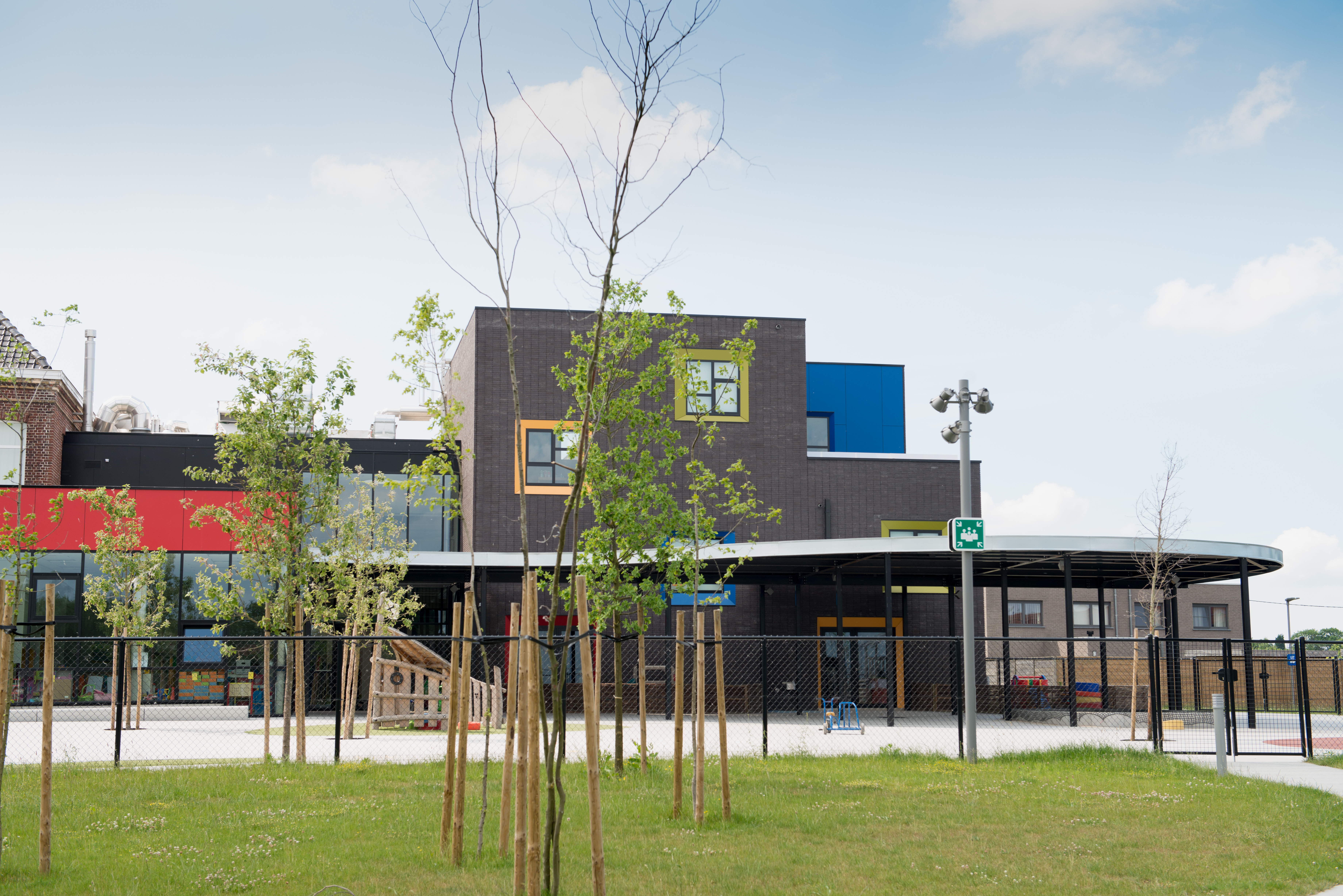 Schoolgebouw met grasveld en speelplaats Basisschool De Ark fotograaf Vanden Broele - Griet Janssens